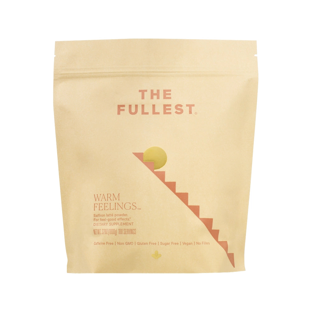 A beige Warm Feelings Bulk package labeled &quot;the fullest saffron latte. warm feelings&quot; with a rising sun graphic and dietary details including caffeine-free, gluten-free, and vegan.