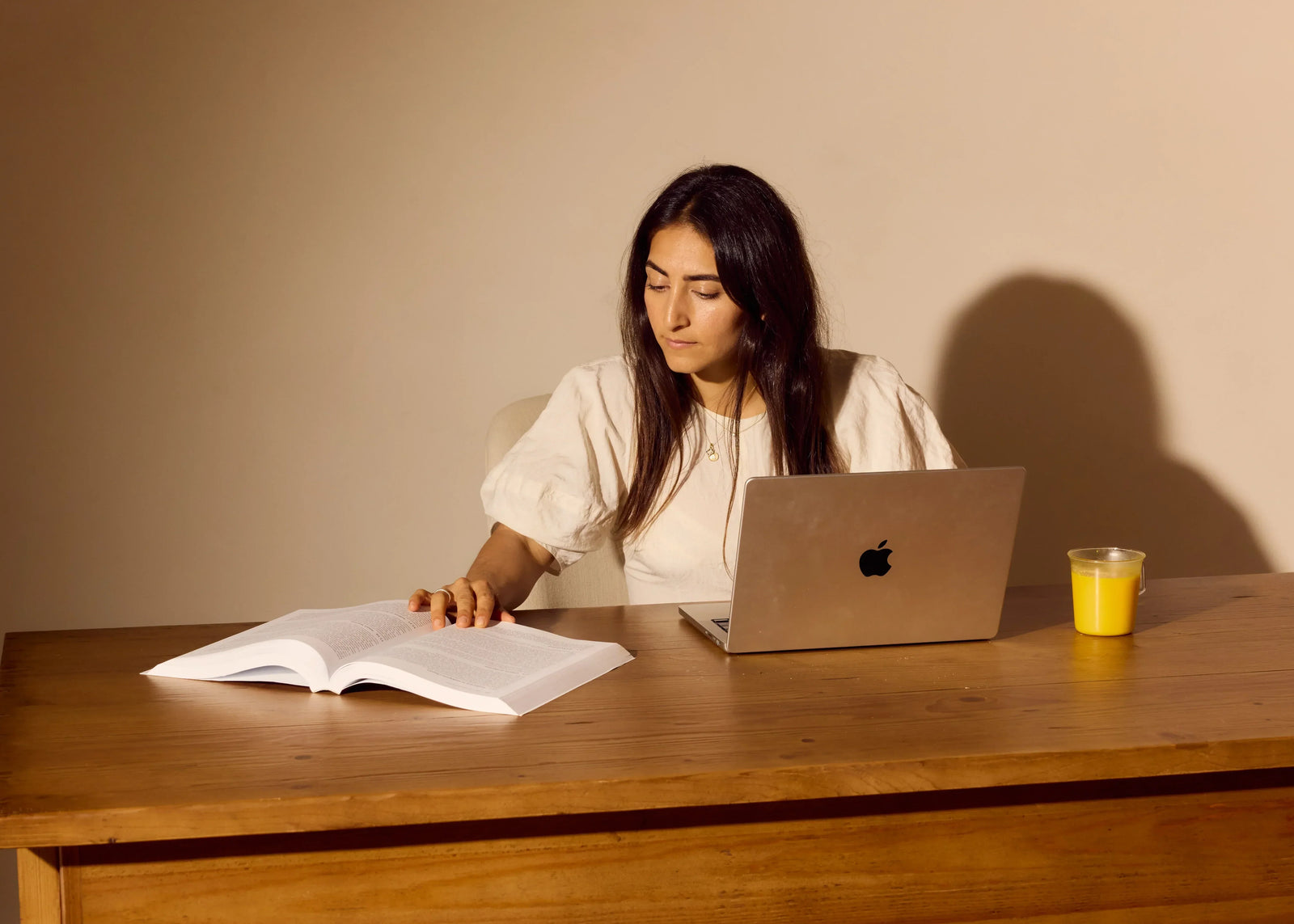 Woman sitting at her desk working on computer with her saffron latte 