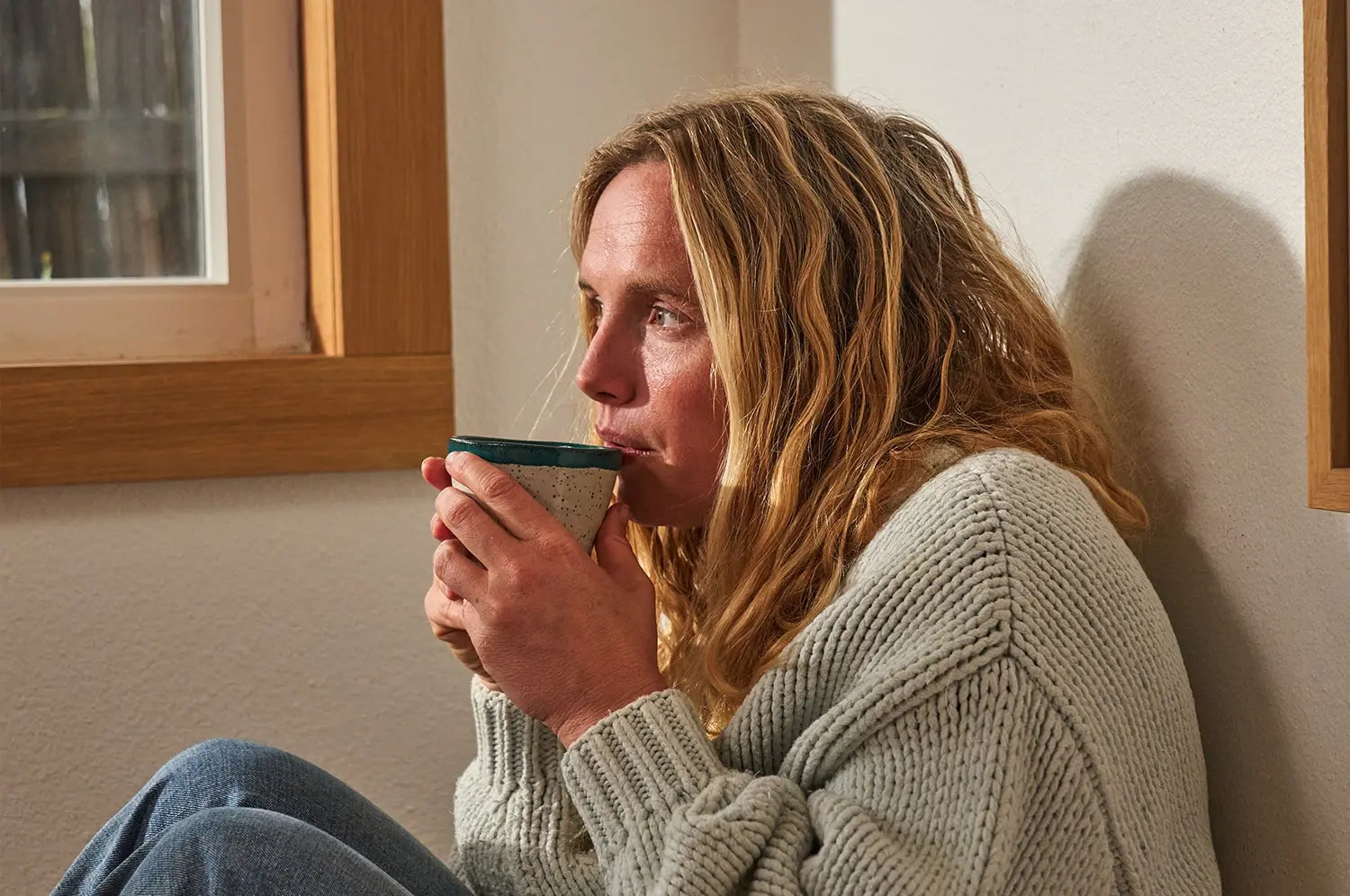 Woman drinking saffron latte out of ceramic mug 