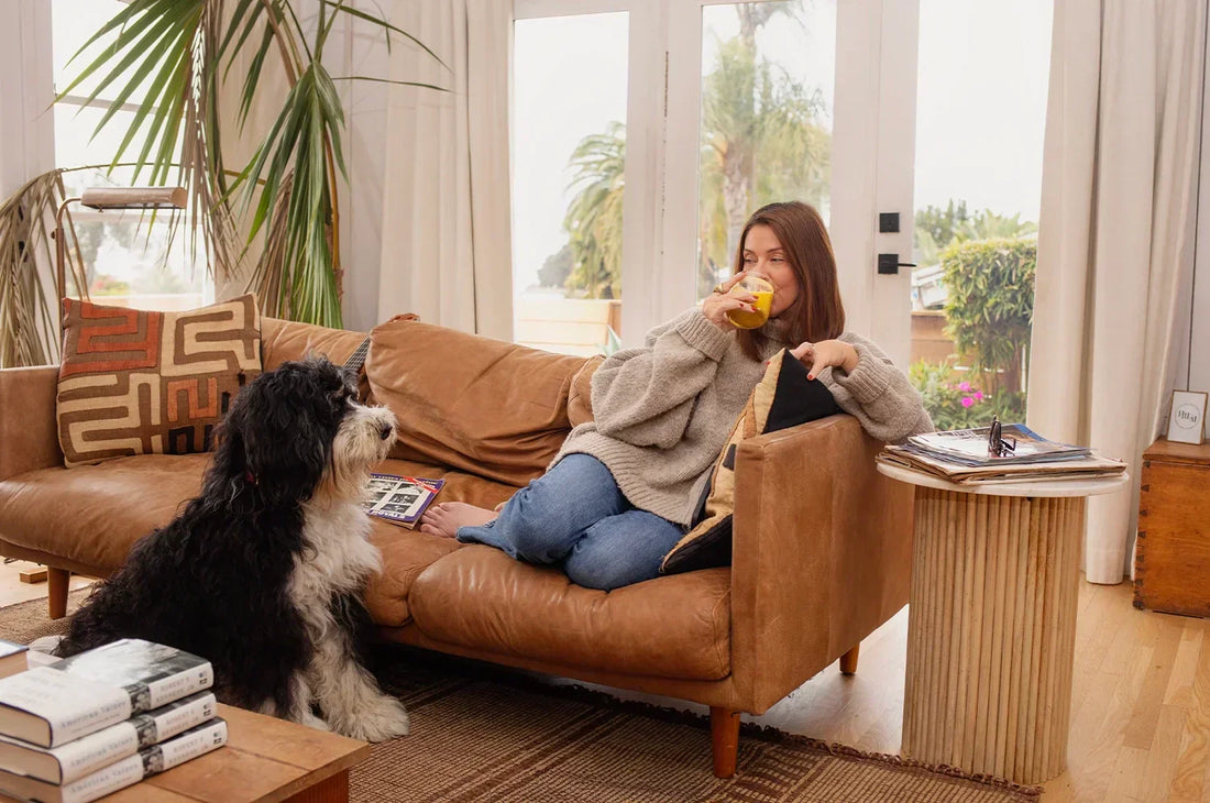 Woman sitting on a couch sipping latte 