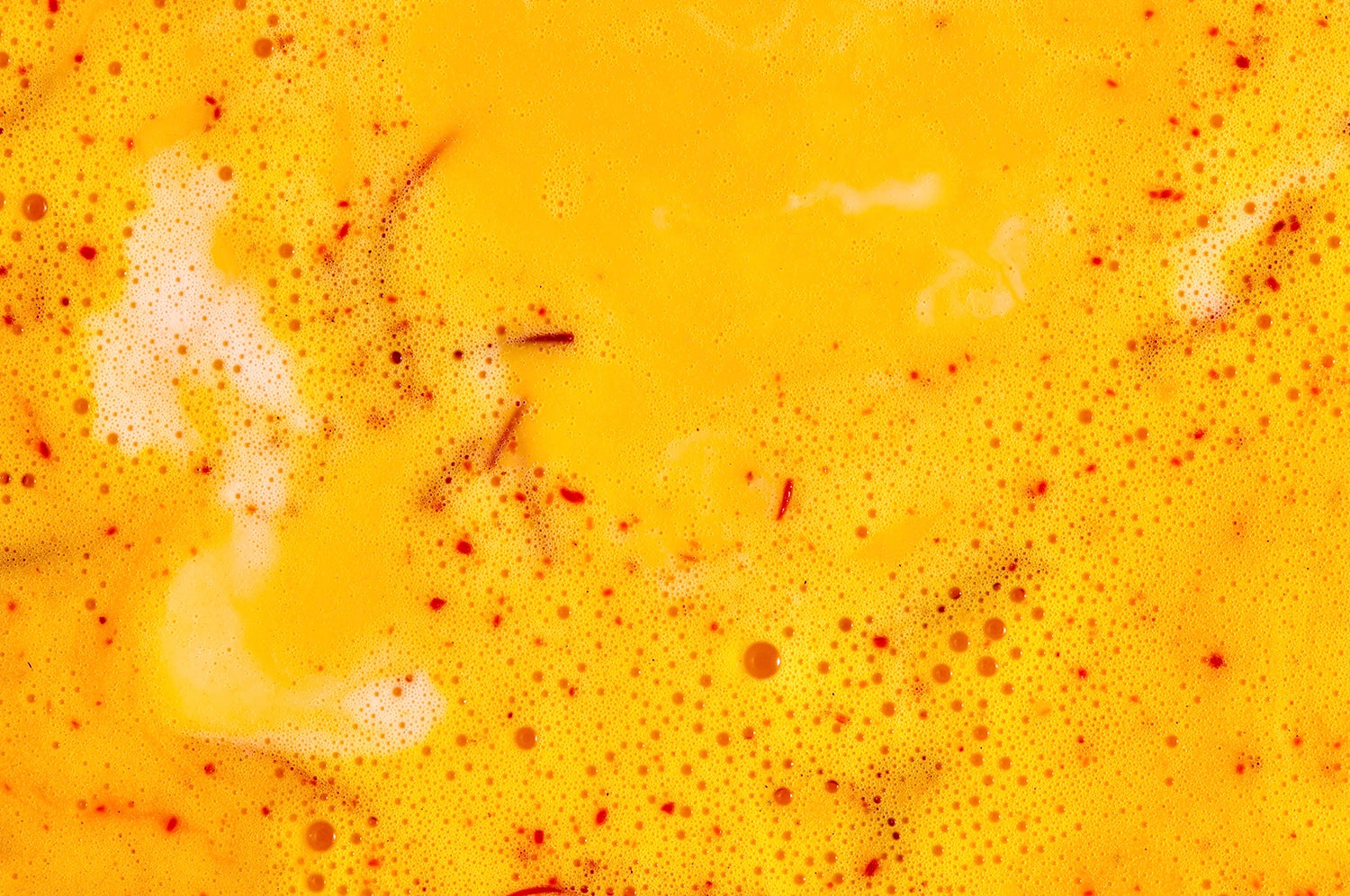 An up-close view of a saffron latte beverage from The Fullest.