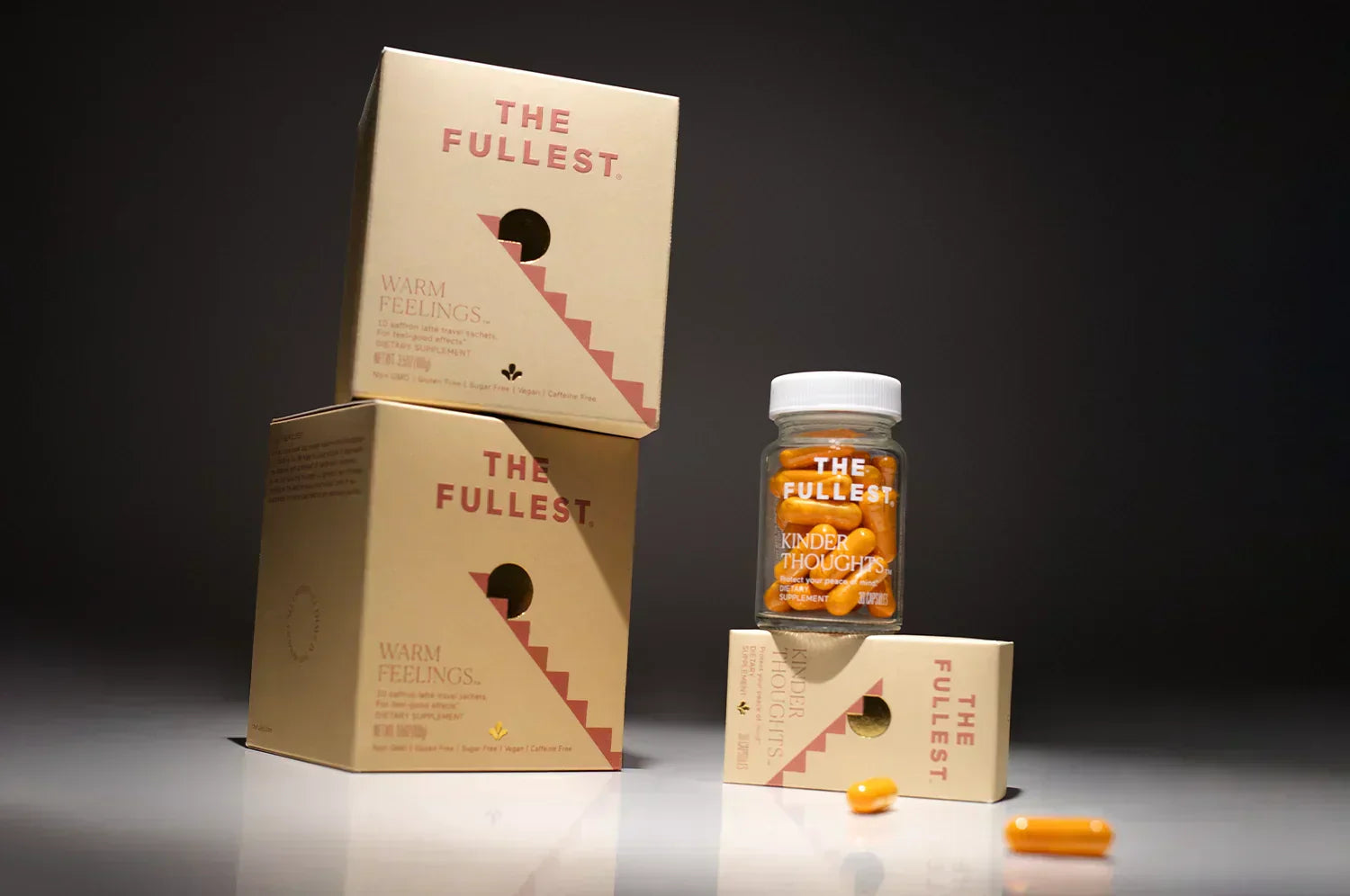 Box of saffron latte sachets & saffron capsules in dark backdrop 