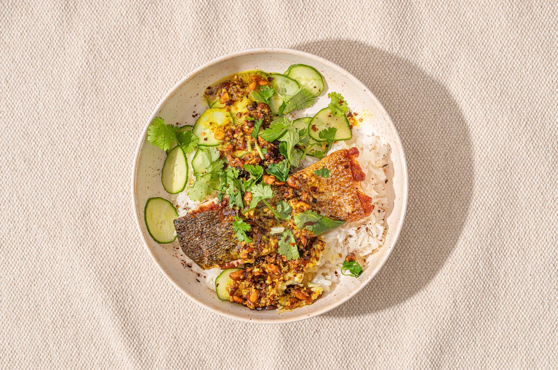 An overhead image of saffron coconut salmon prepared with The Fullest's Warm Feelings saffron mix, served in a white bowl on a surface.