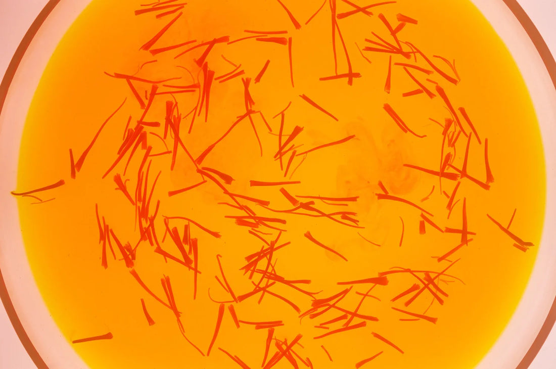 A close-up of a glass with saffron beverage topped with saffron threads from The Fullest.