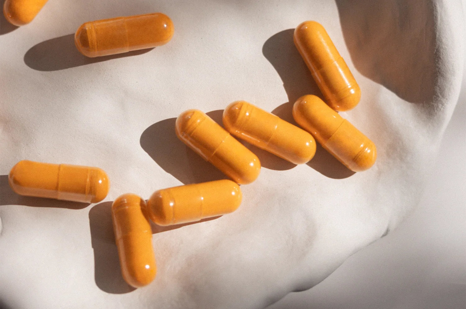 A bunch of THE FULLEST's Kinder Thoughts saffron capsules resting on a ceramic plate.