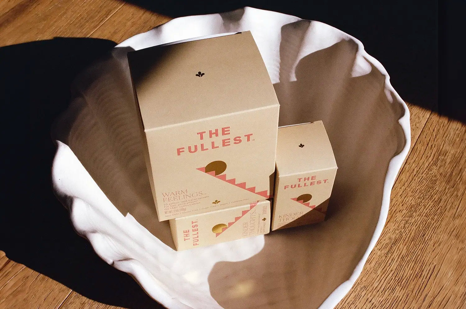 On the countertop sits a white shell-shaped dish holding three boxes of saffron products from THE FULLEST.