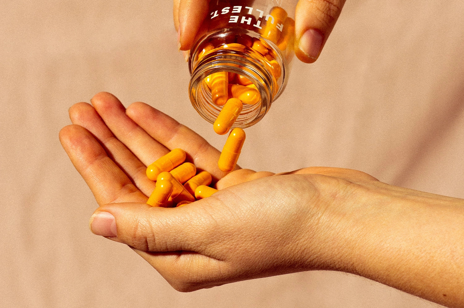 Hand held out with saffron capsules being spilled into her hand
