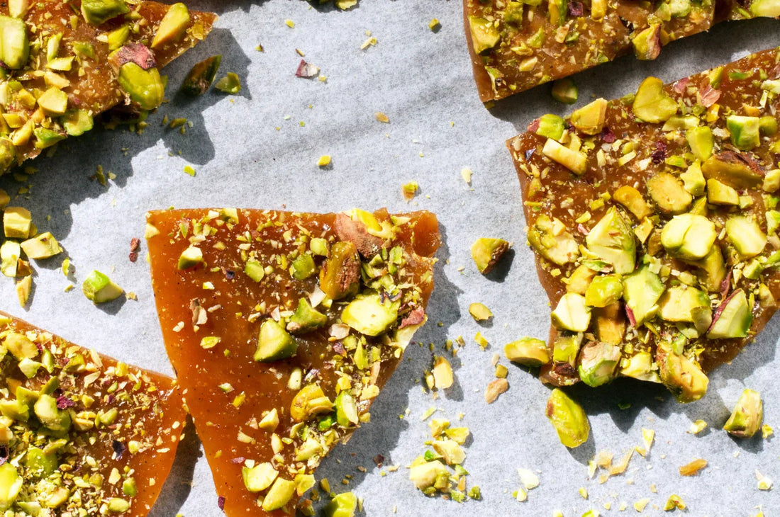 A close up photo of THE FULLEST's saffron pistachio toffee on parchment paper.