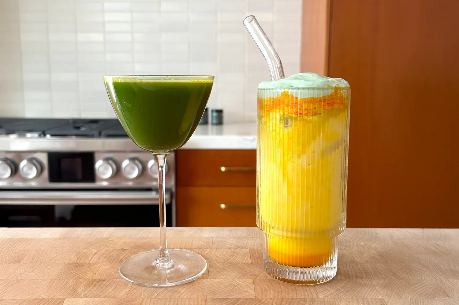 Saffron latte next to detox green drink in a glass 