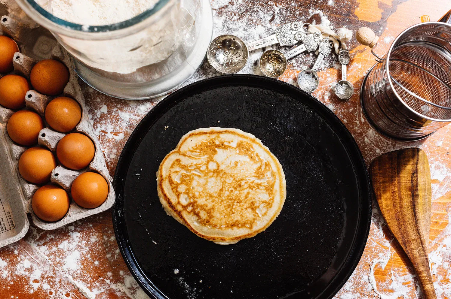 Saffron pancake on a cast iron skillet with eggs and rustic backdrop 