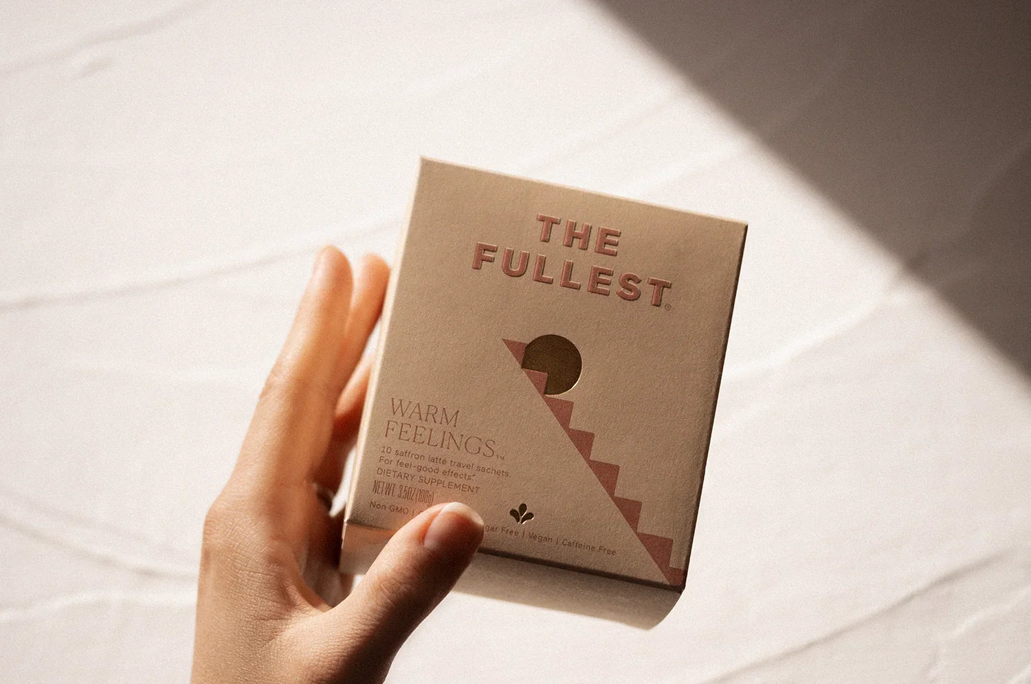 Hand holding THE FULLEST saffron latte sachet box 