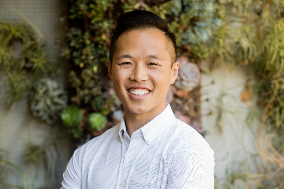 Dr. Calvin Ng standing outside in front of a building, facing the camera, smiling.