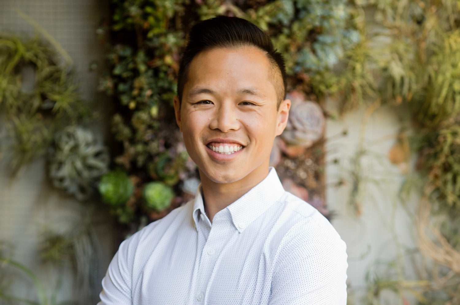 Dr. Calvin Ng standing outside in front of a building, facing the camera, smiling.