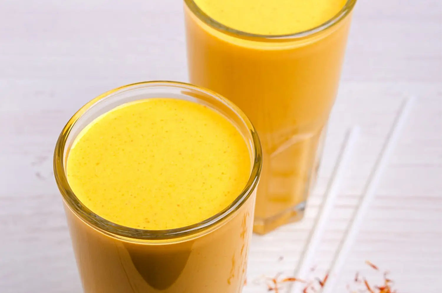 High resolution image of a creamy golden saffron milkshake with a neutral background 