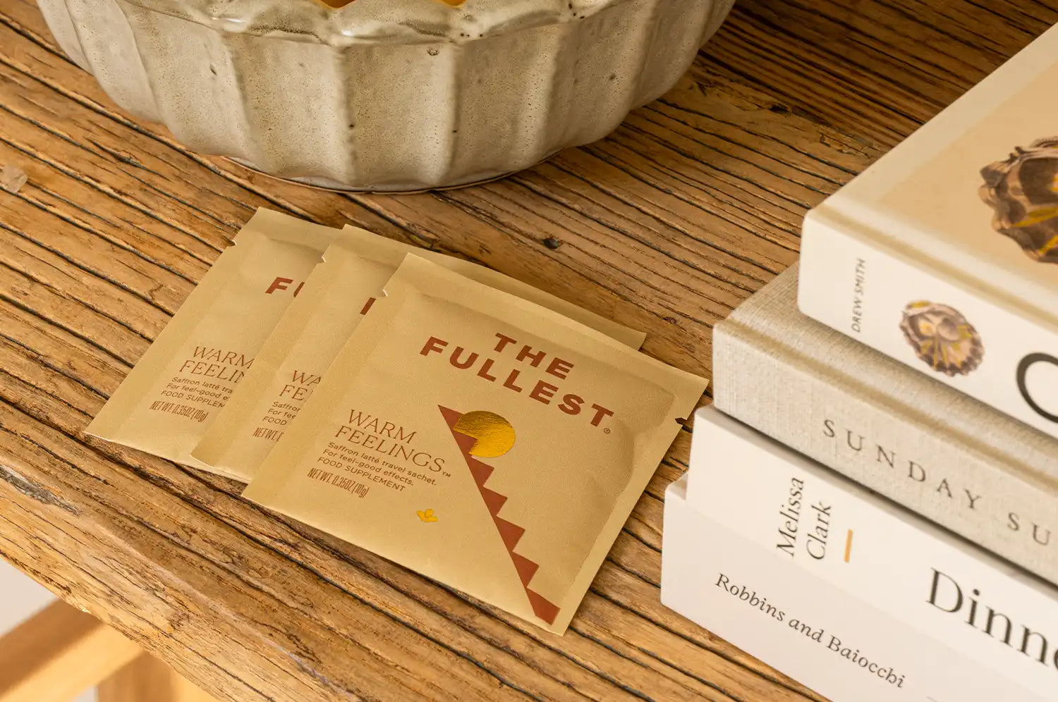 THE FULLEST Saffron Latte single serving sachets on a wooden table