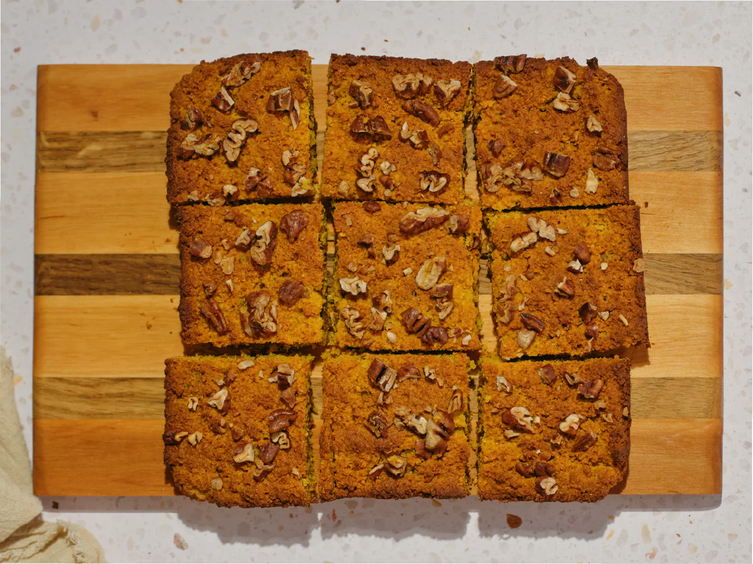 Saffron & maple pecan blondies on a wooden cutting board