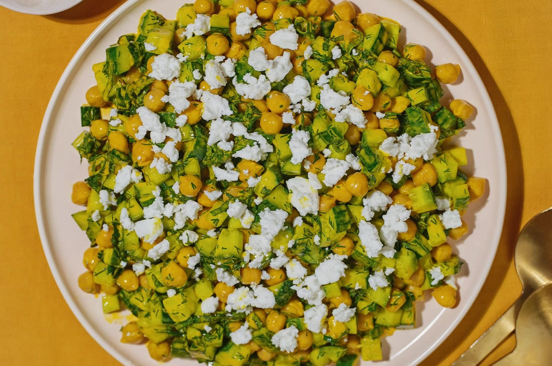 A vibrant herby saffron chickpea salad topped with fresh herbs and citrus, served in a bowl on a neutral surfac
