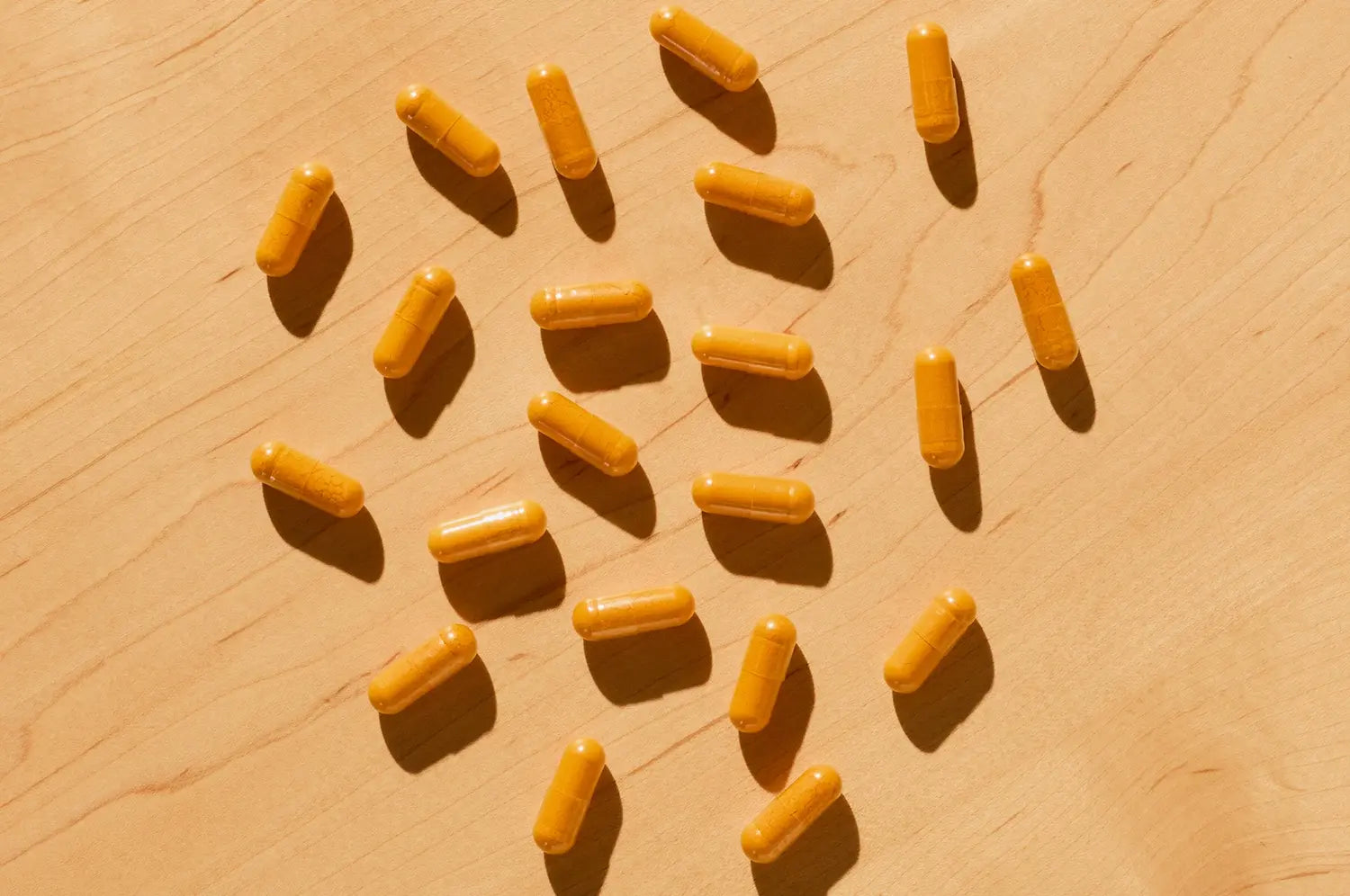 Saffron capsules spilled on a wooden table 