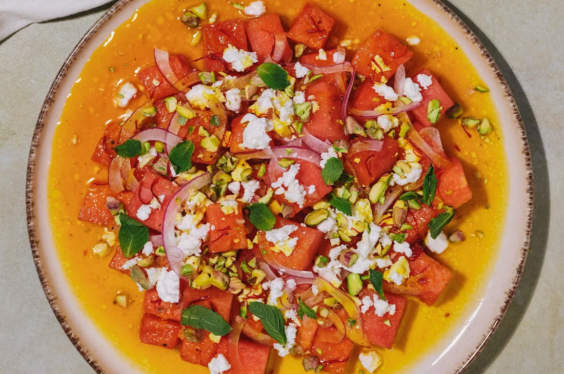 Saffron Watermelon Feta Salad with fresh herbs on a ceramic plate 