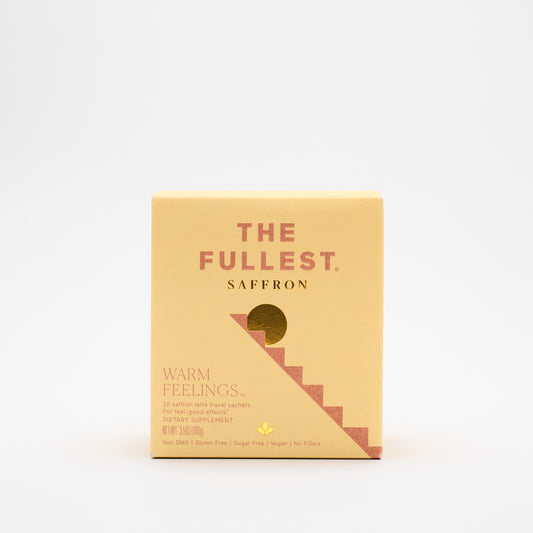 A yellow box labeled "THE FULLEST Saffron Latte 10 Single-Serving Sachets" features a minimalist design with a stairs graphic and highlights benefits like mood support, plus vegan, non-GMO, and gluten-free attributes.