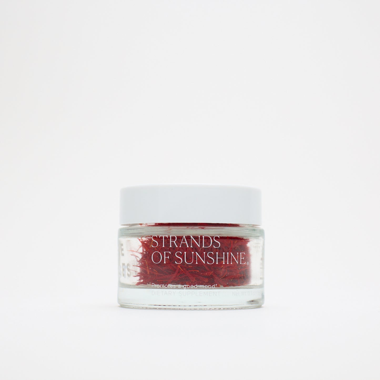 A small glass jar with a white lid, labeled "THE FULLEST Saffron Threads," holds vivid saffron strands and is set against a plain white background.
