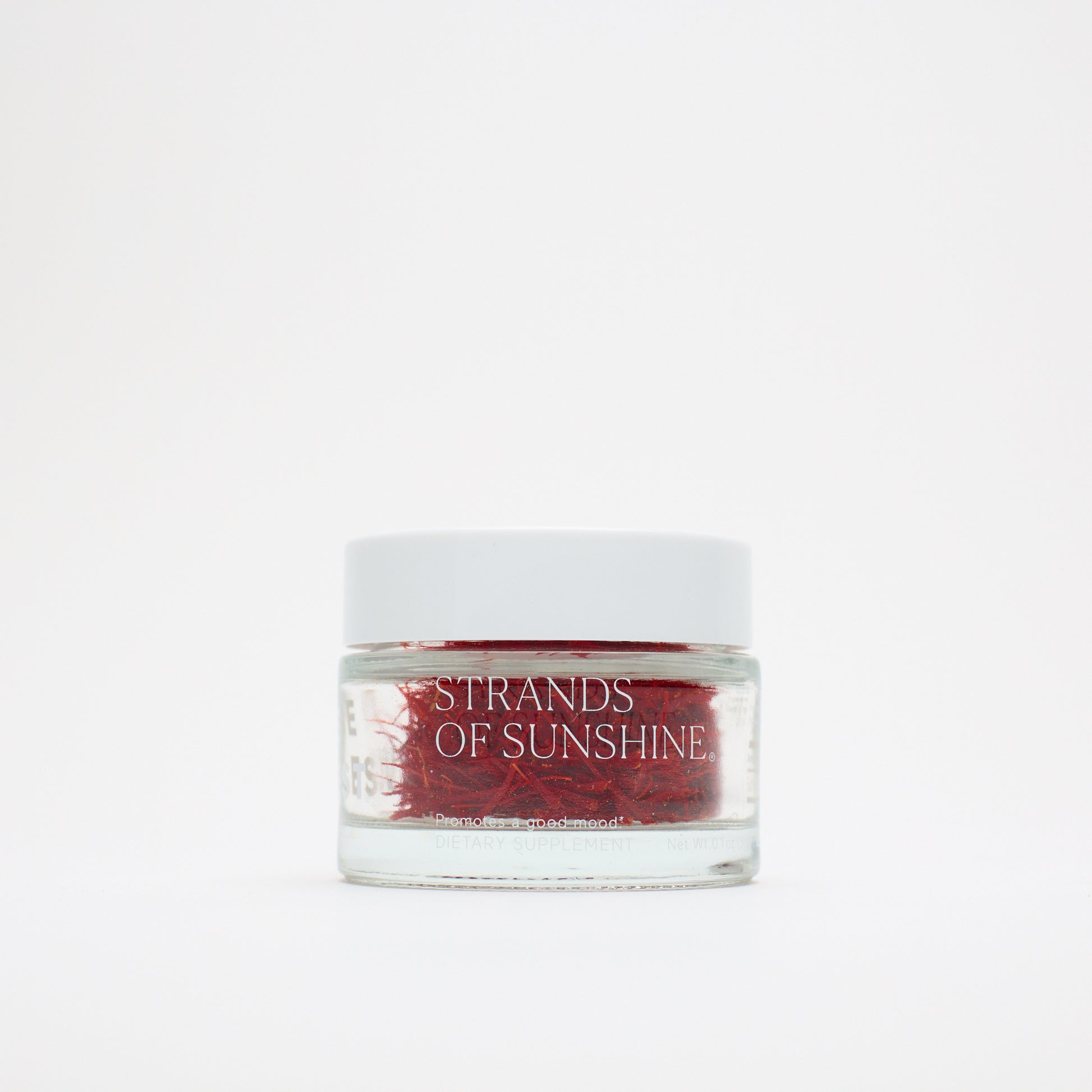 A small glass jar with a white lid, labeled "THE FULLEST Saffron Threads," holds vivid saffron strands and is set against a plain white background.