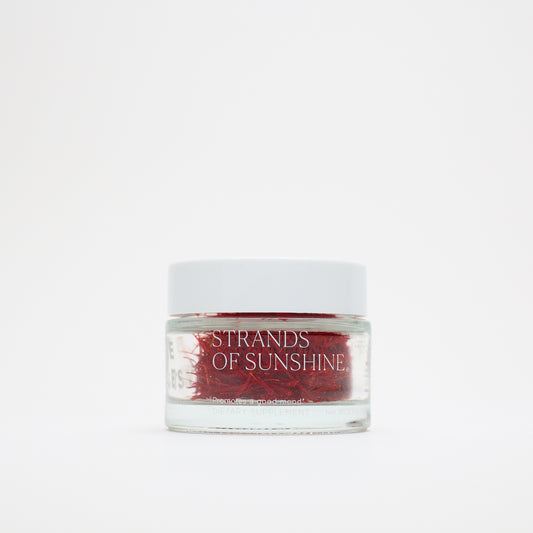 A small glass jar with a white lid, labeled "THE FULLEST Saffron Threads," holds vivid saffron strands and is set against a plain white background.