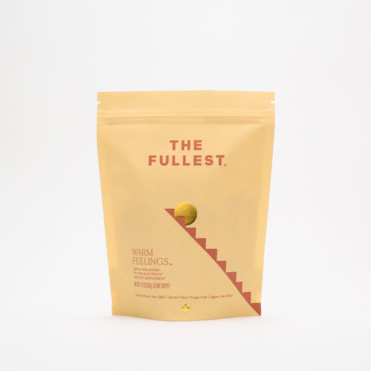 A yellow resealable pouch labeled "THE FULLEST Saffron Latte 30-Day Supply" stands upright on a white background with minimalist graphics, highlighting it as a caffeine-free dietary supplement.