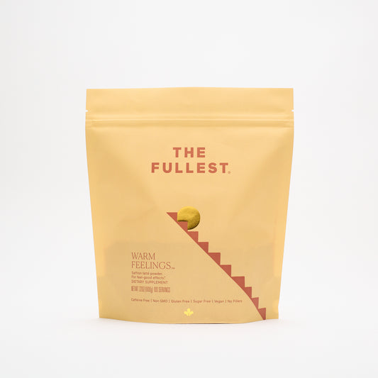 A matte yellow resealable pouch labeled “THE FULLEST.” contains the Saffron Latte 100-Day Supply, a caffeine-free blend designed to boost mood and enhance restorative sleep, with product details printed on the front.