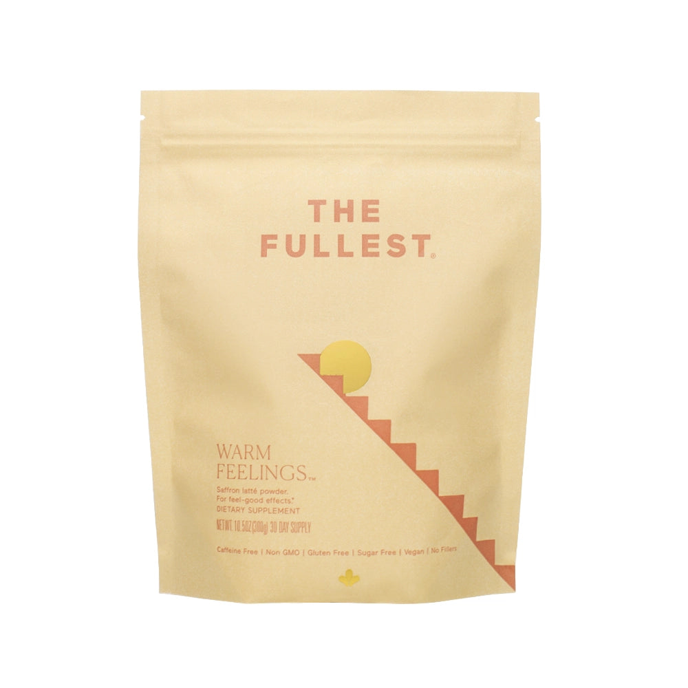 A beige Warm Feelings Bag by THE FULLEST labeled with &quot;warm feelings&quot; and a minimalist design of a sun and staircase, suggesting it&#39;s a caffeine-free dietary supplement.