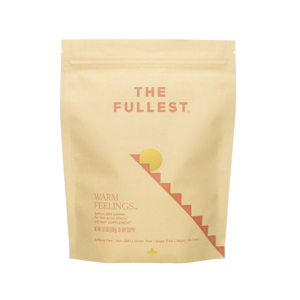 A beige Warm Feelings Bag by THE FULLEST labeled with &quot;warm feelings&quot; and a minimalist design of a sun and staircase, suggesting it&#39;s a caffeine-free dietary supplement.